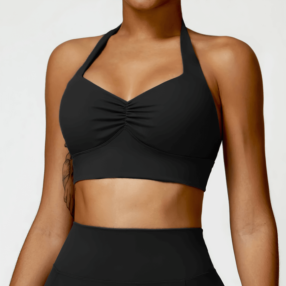 Woman wearing a sexy racerback sports bra with removable padding, perfect for yoga and gym sessions, offering style and support.
